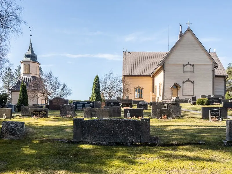 Auran kirkko ja hautausmaa keväisessä maisemassa.