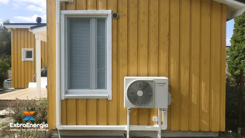 Ilmalämpöpumpun ulkoyksikkö omakotitalon seinällä.